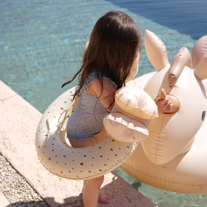 Photo d'une petite fille qui a la bouée multi hearts de chez Konges Slojd