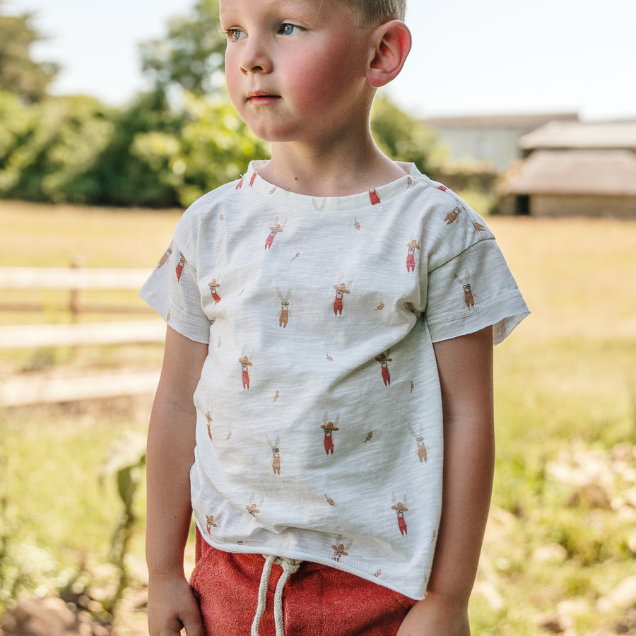 Photo du tee-shirt imprimé lapin Mae de chez Les Petites Choses porté par un garçon à la ferme