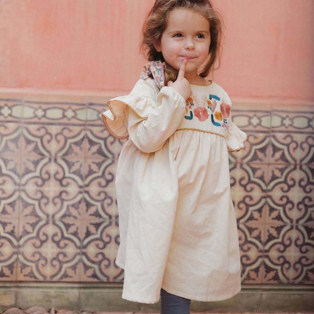 Photo d'une fille qui porte la robe Illia brodée crème DE Louise Misha 