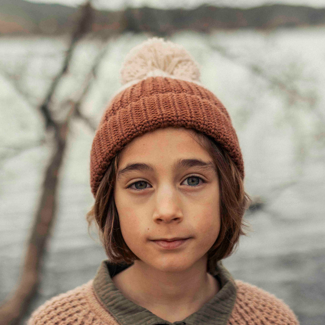 Bonnet en maille beige et chocolat de Bùho porté par un garçon