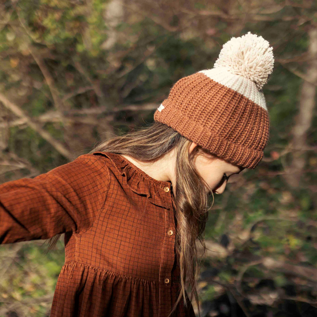 Bonnet en maille beige et chocolat de Bùho porté par une fille