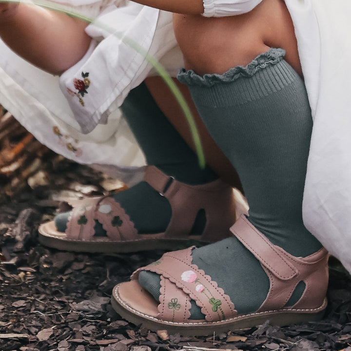 Photo des sandales brodées blooming rose de la collection Uniqua de chez Petit Nord portées par une petite fille